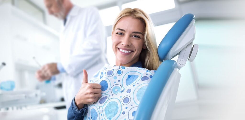 woman giving her thumbs up at the dentist